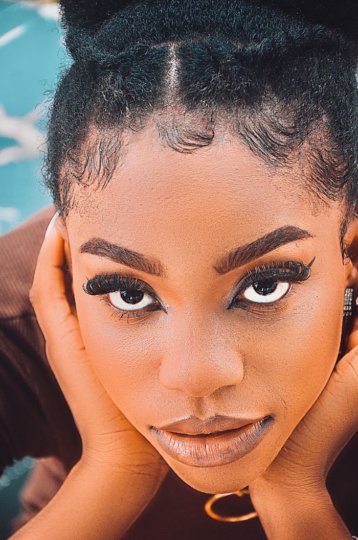 Close-up portrait capturing a young woman's intense gaze and bold eye makeup.